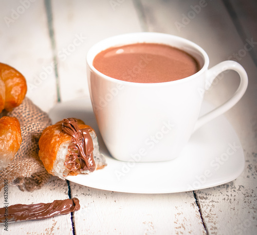 Fresh baked croissants with chocolate cream and hot cocoa on woo photo