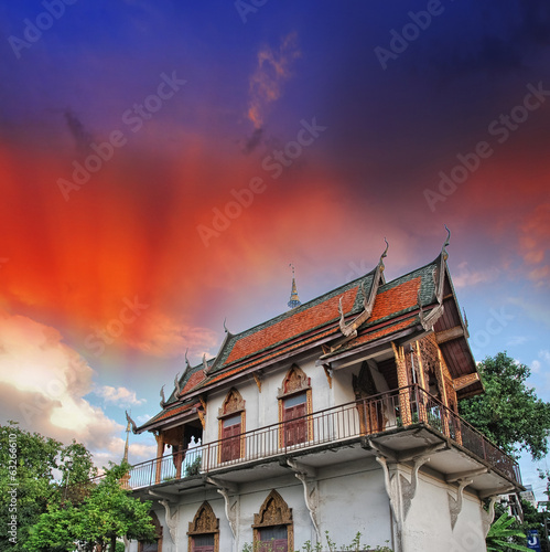 Thailand. Temple surrounded by vegetation with sunset sky on bac