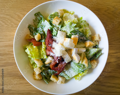  caesar salad placed on top of a wooden table