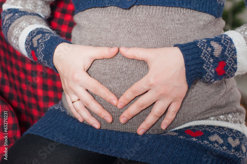 The hands on the abdomen of a pregnant woman