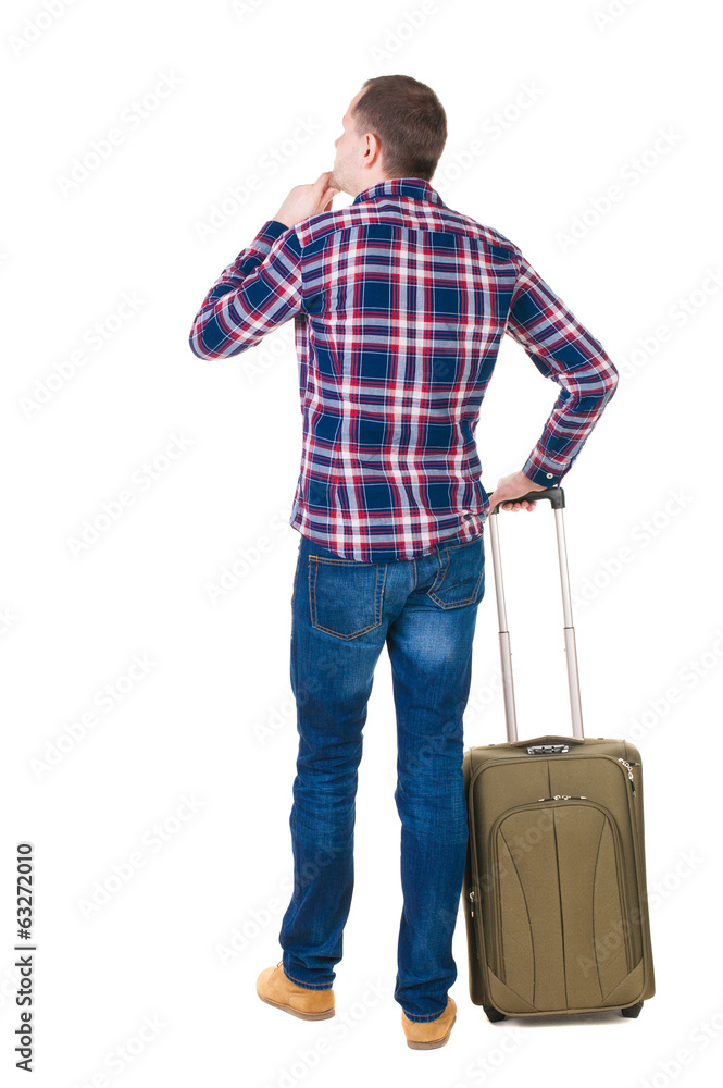 Back view of man with green suitcase looking up. Back view of man with green suitcase looking up.