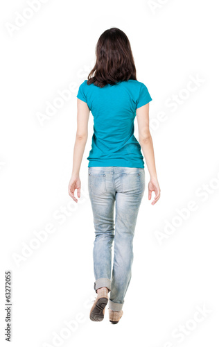 back view of walking woman in jeans .