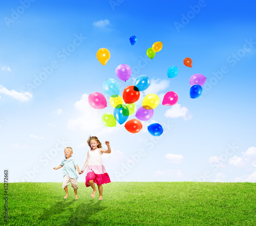Little Girl and Boy Outdoors Holding Balloons