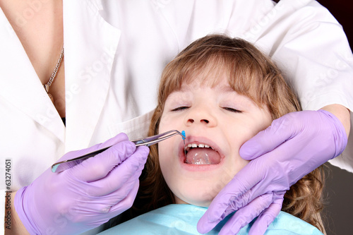 dentist treats tooth little girl