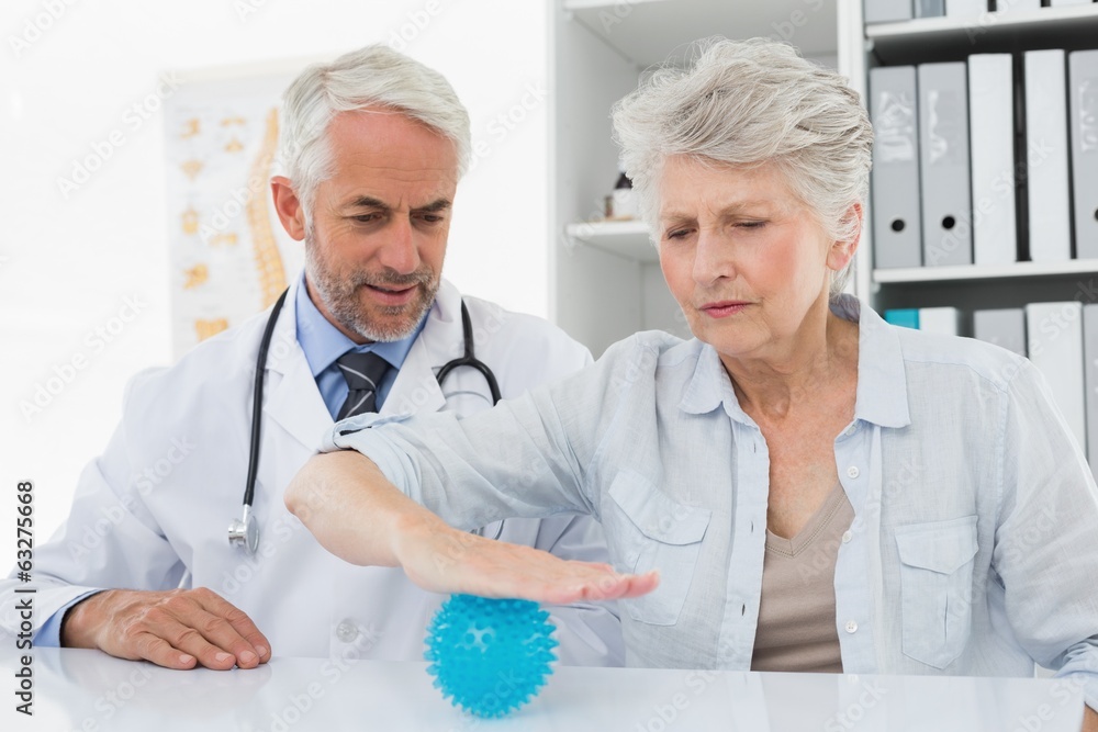 Male doctor with senior patient using stress buster ball Male doctor with senior patient using stress buster ball