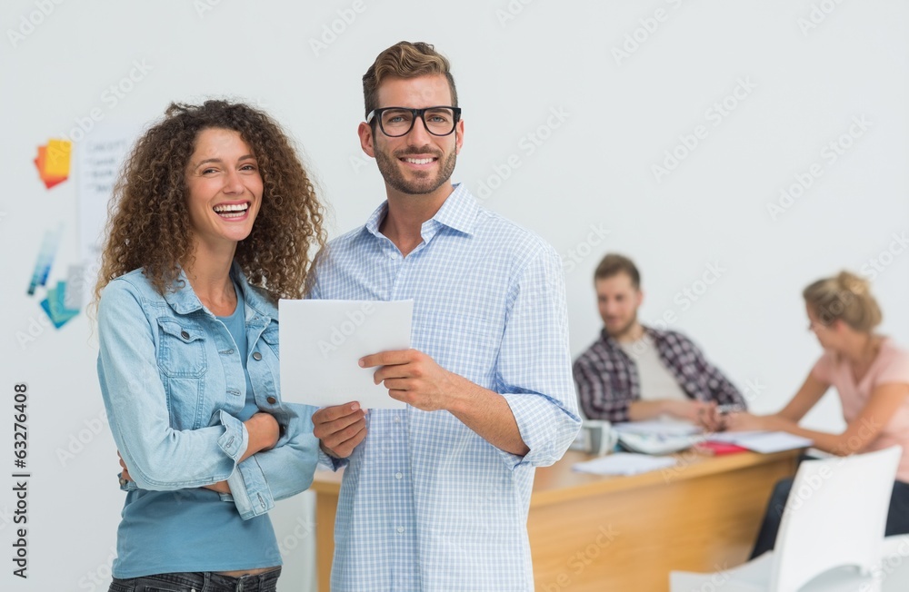 Happy designers using digital tablet smiling at camera Happy designers using digital tablet smiling at camera