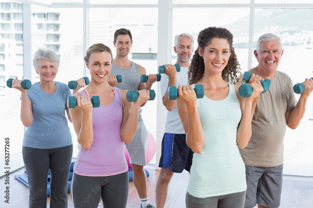 Class exercising with dumbbells in gym Class exercising with dumbbells in gym