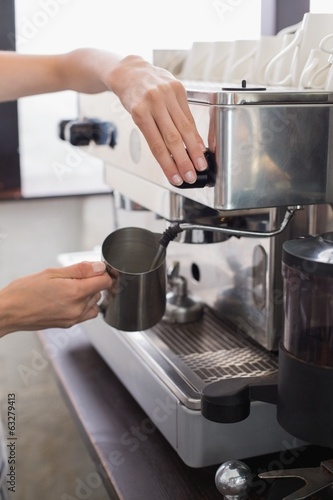 Mid section of a barista prepares espresso in coffee shop © lightwavemedia
