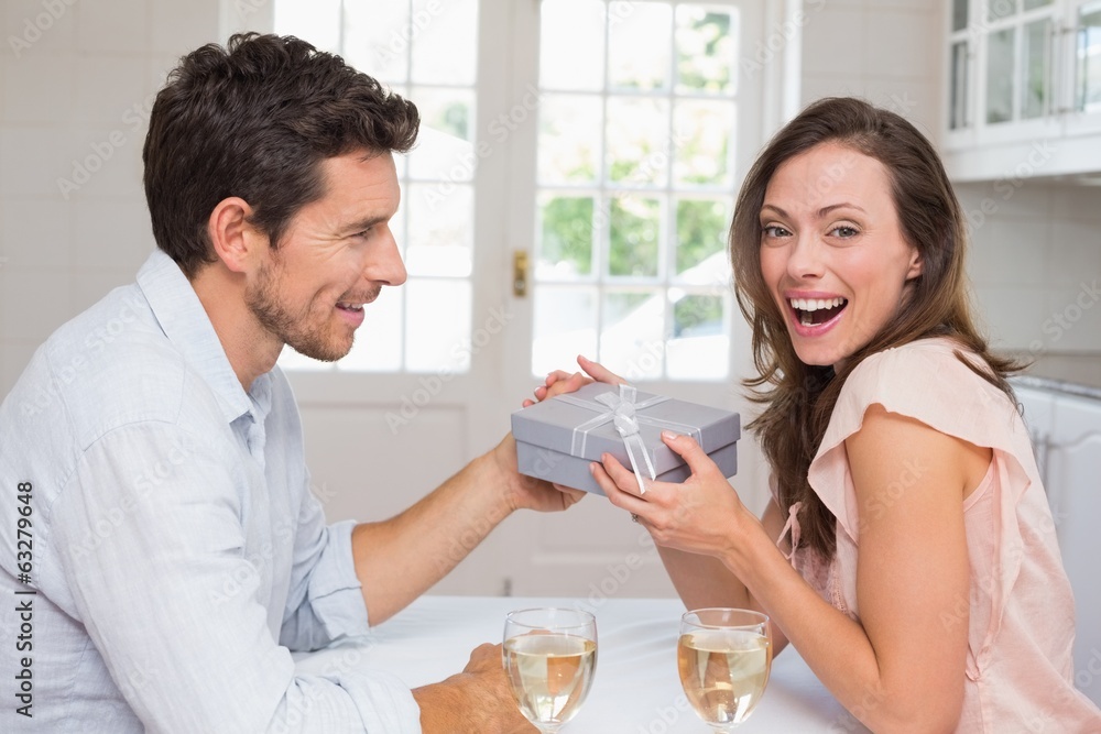 Young man giving a happy woman gift box