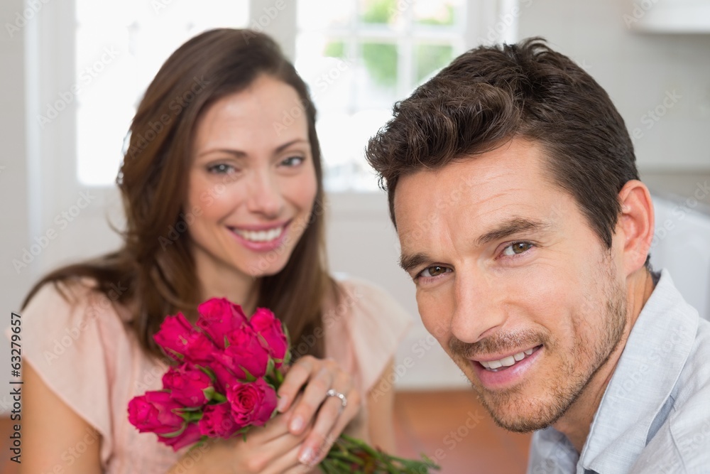 Happy young couple with flowers at home