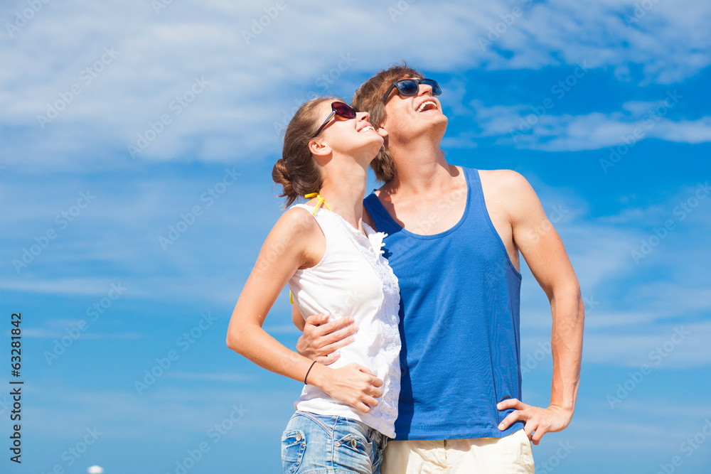Closeup of happy young couple in sunglasses on beach smiling and Closeup of happy young couple in sunglasses on beach smiling and