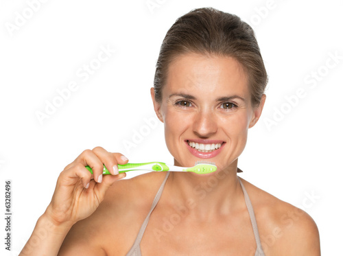 Portrait of smiling young woman brushing teeth