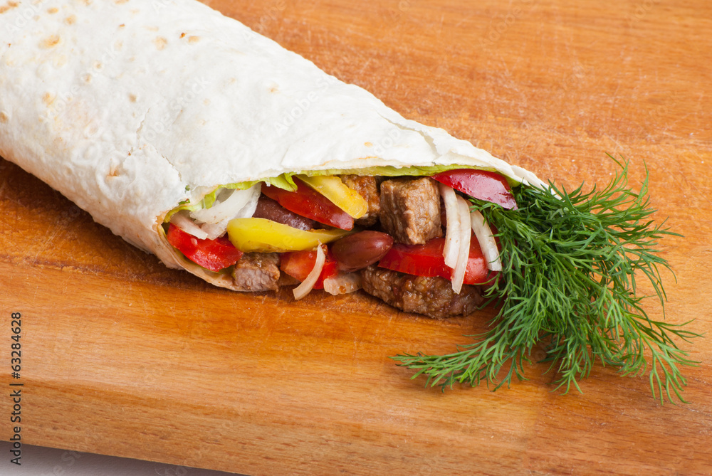 Obraz premium beef burrito with peppers, onion and tomato
