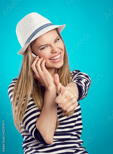 Happy toothy woman with phone showing thumb up
