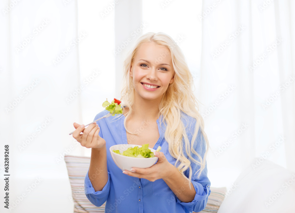 smiling young woman with green salad at home smiling young woman with green salad at home