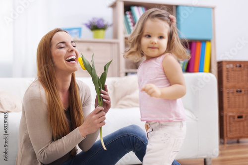 Beautiful mother enjoying the flower which she received