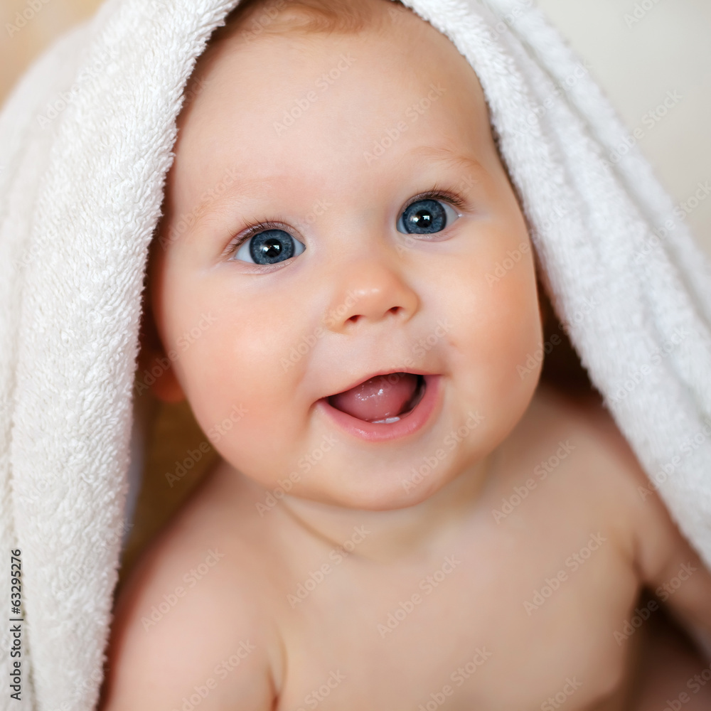 A beautiful smiling baby wrapped in quilt A beautiful smiling baby wrapped in quilt