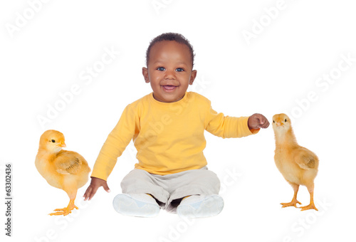 Adorable african baby sitting wity two little yellow chickens photo