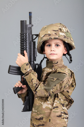 Young boy dressed like a soldier with rifle