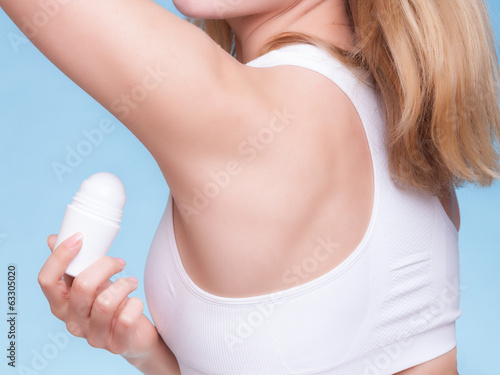 Girl applying stick deodorant in armpit. Skin care
