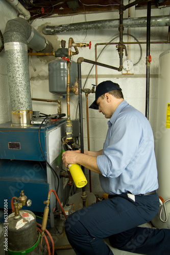 Service technician repairs furnace