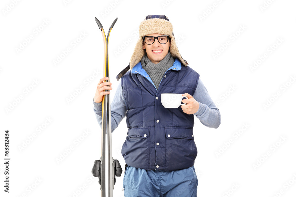 Male skier holding a cup of hot tea Male skier holding a cup of hot tea