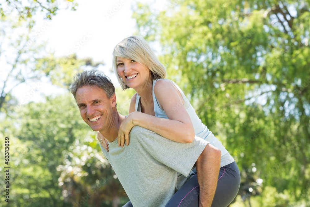 Couple enjoying piggyback ride in park Couple enjoying piggyback ride in park