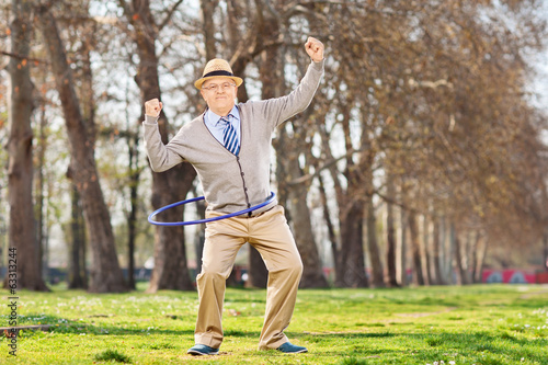 Senior man, exercise with a hula hoop in park