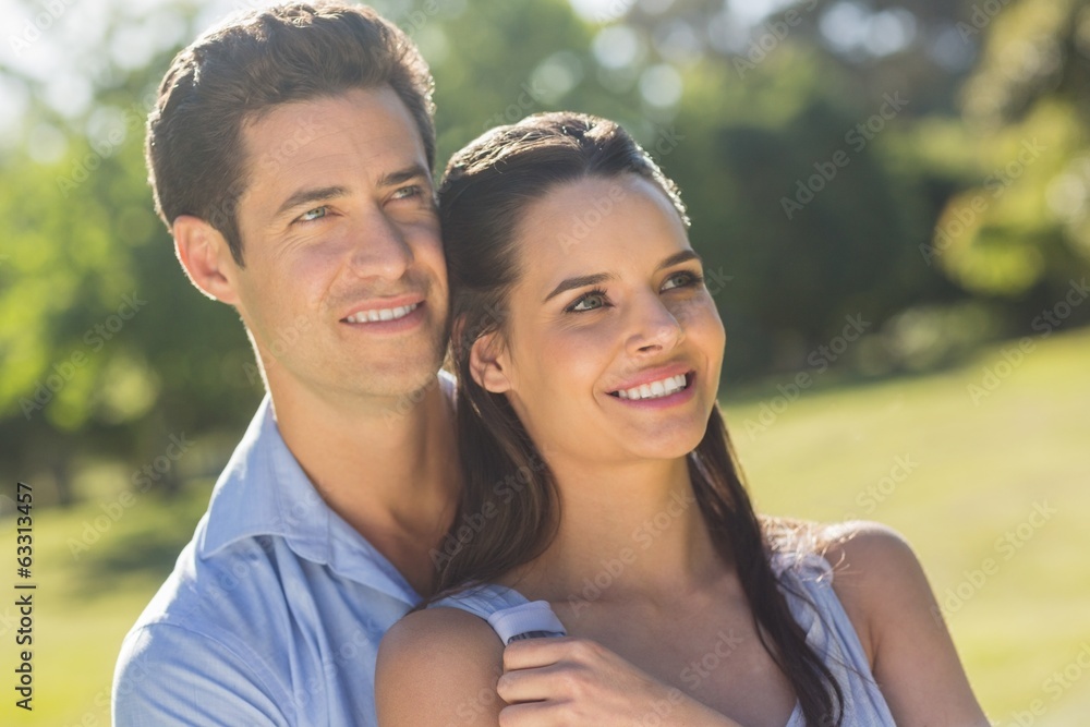 Loving and happy couple looking away at park Loving and happy couple looking away at park