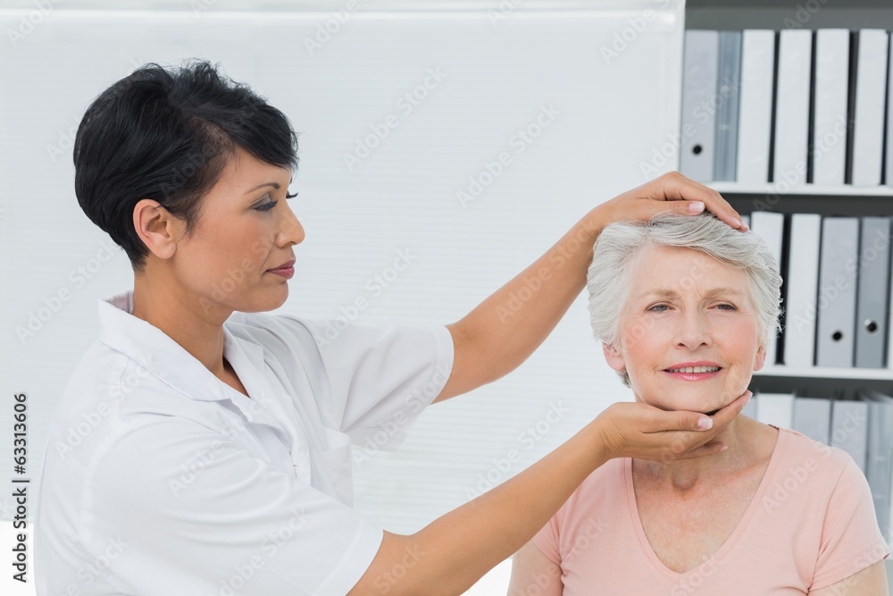 Female chiropractor doing neck adjustment Female chiropractor doing neck adjustment
