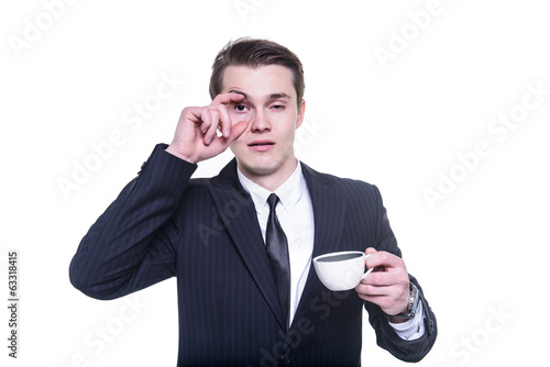 businessman tired and falling asleep drinking a cup of coffee
