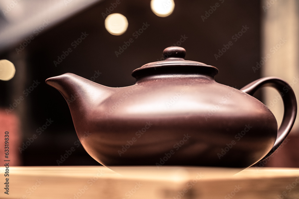 Clay teapot on a wooden plank