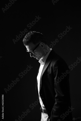 Black and white photo of a pensive businessman in glasses