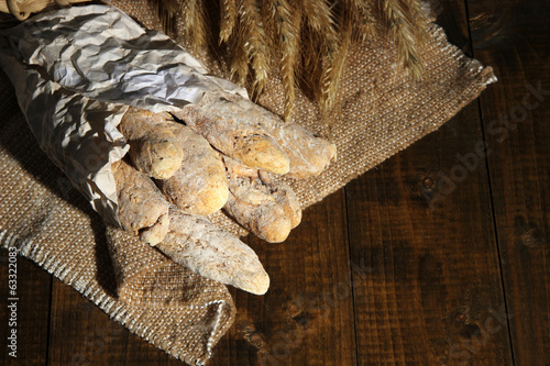 Bread sticks on sackcloth on wooden background