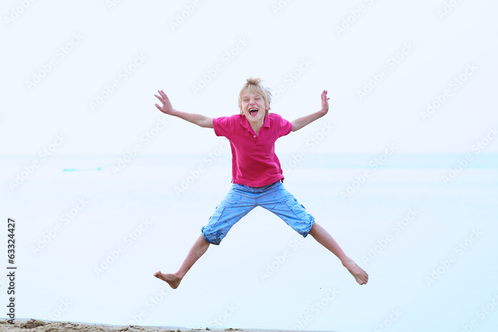 Happy active boy jumping on the beach