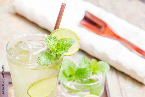 Iced green tea with lime garnish and ice cube