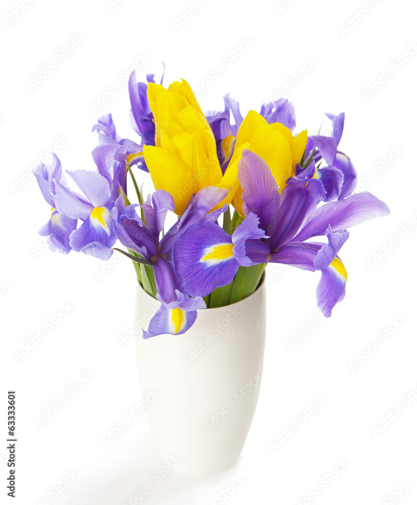 Irises and tulips in the white vase isolated on white. Irises and tulips in the white vase isolated on white.