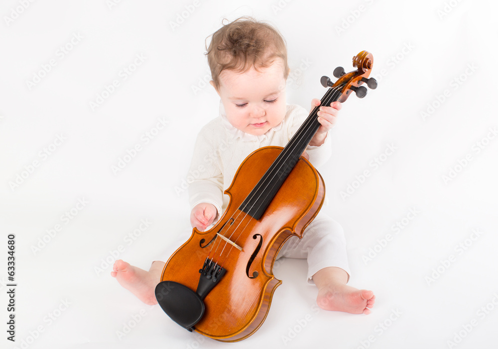 Beautiful baby girl playing with a violin