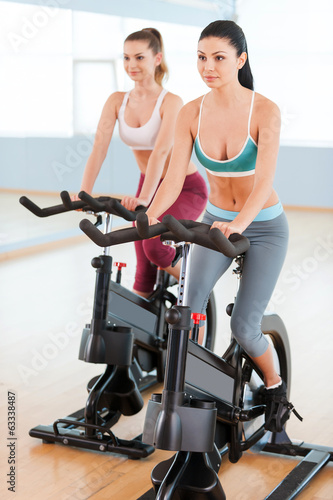 Women on exercise bikes.