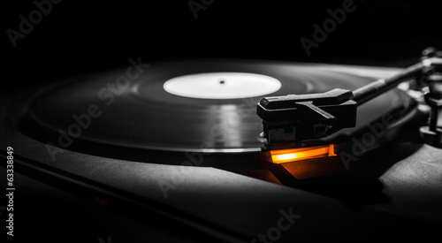 old style turntable with needle - b&w and orange light photo