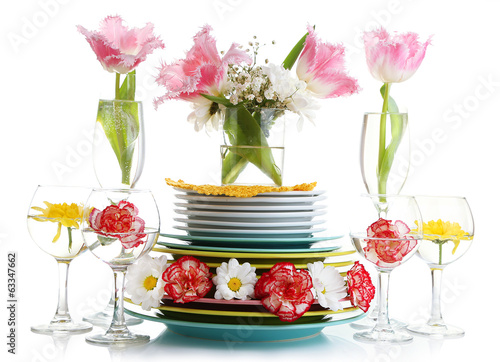 Stack of colorful ceramic dishes and flowers, isolated on white