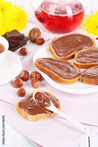 Bread with sweet chocolate hazelnut spread on plate on table