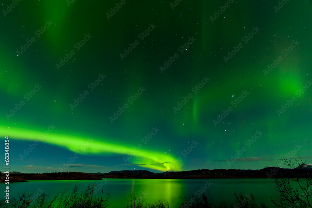 Aurora borealis show Lake Laberge surface mirrored