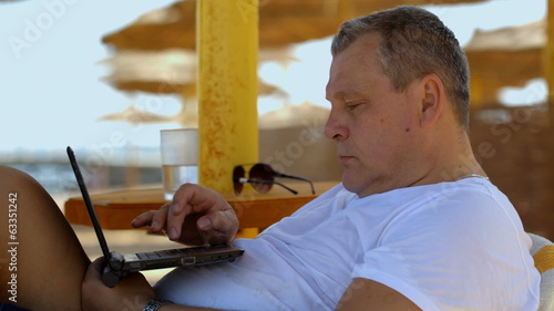 Man with laptop on the beach photo