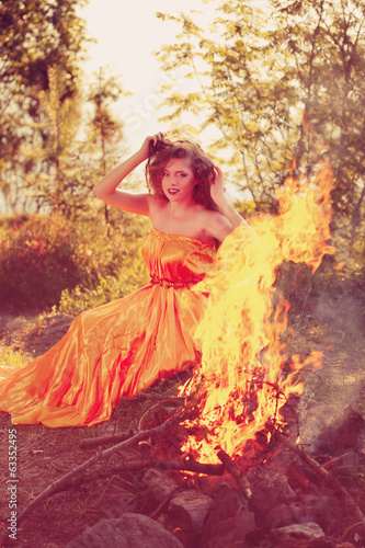 Beauty witch in the woods near the fire. Magic woman celebrating