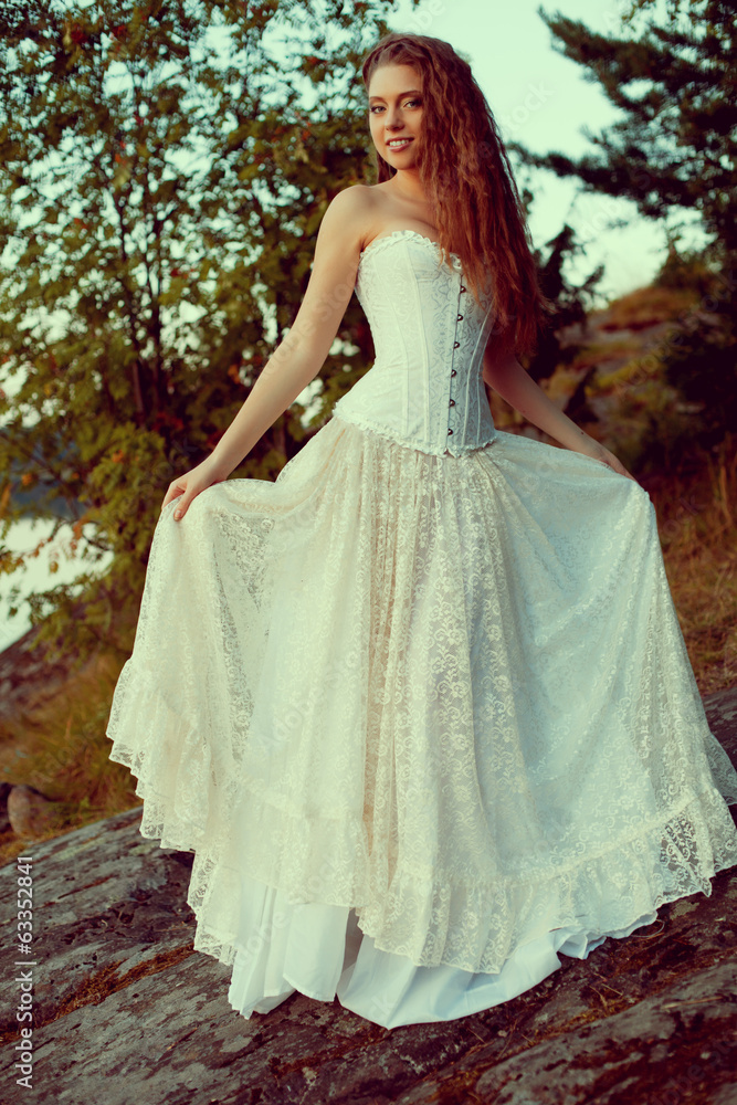 Luxury woman in a forest in a long vintage dress near the lake. Luxury woman in a forest in a long vintage dress near the lake.