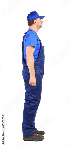 Worker in blue overalls. Side view.