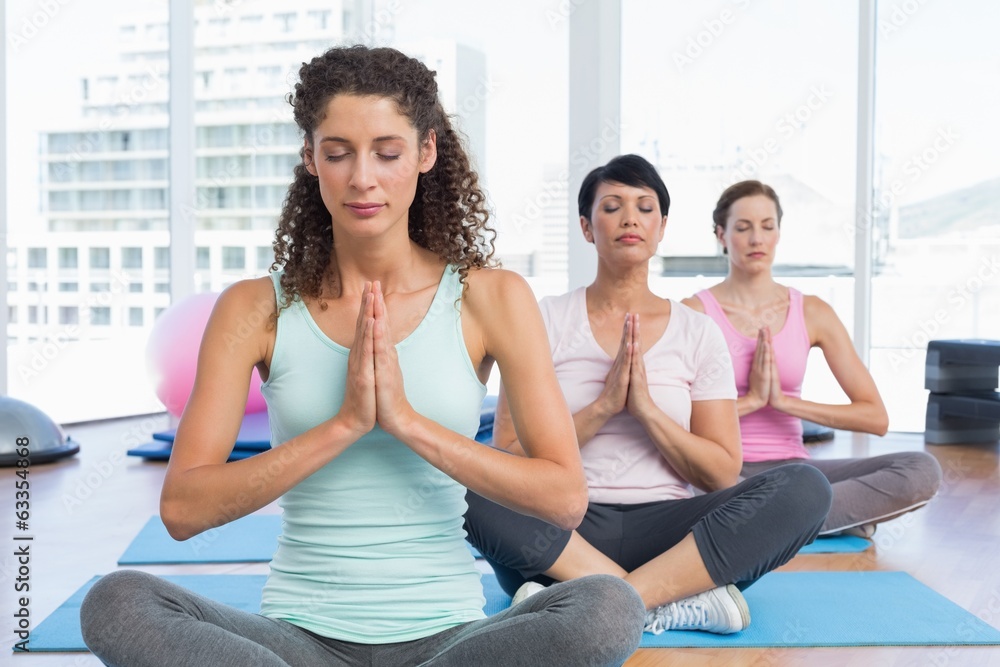 Women with eyes closed and joined hands at fitness studio Women with eyes closed and joined hands at fitness studio
