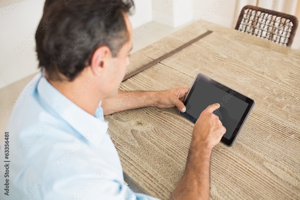 Concentrated man using digital table in kitchen Concentrated man using digital table in kitchen