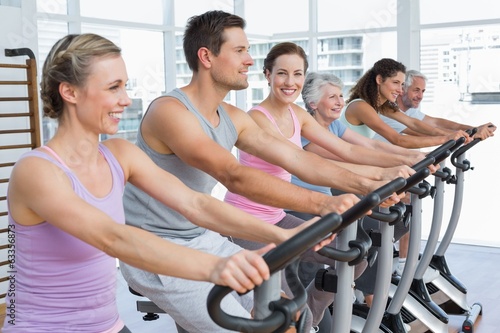 Happy people working out at spinning class